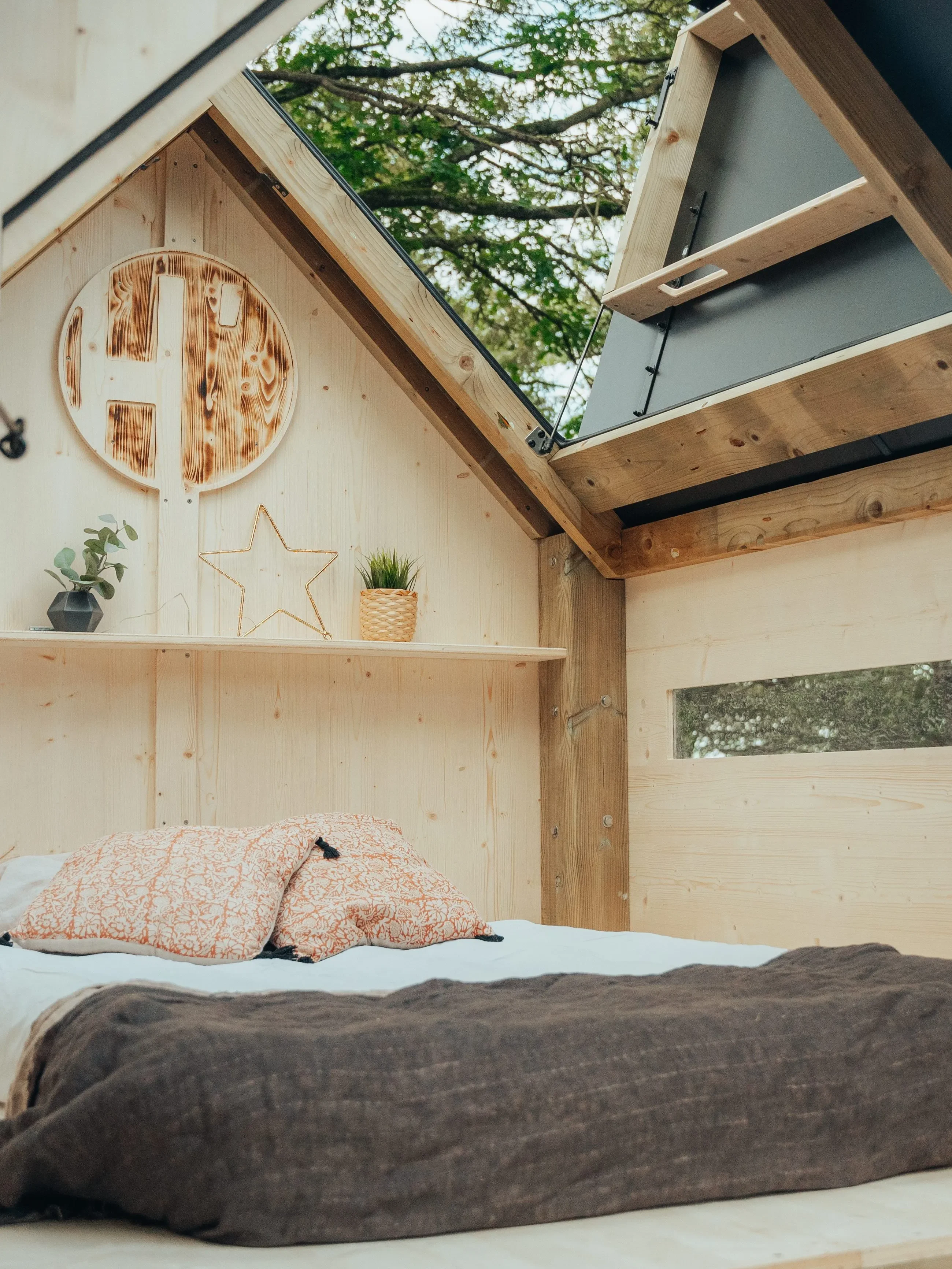L'intérieur de la cabane Hut'Op avec un matelas et de la décoration
