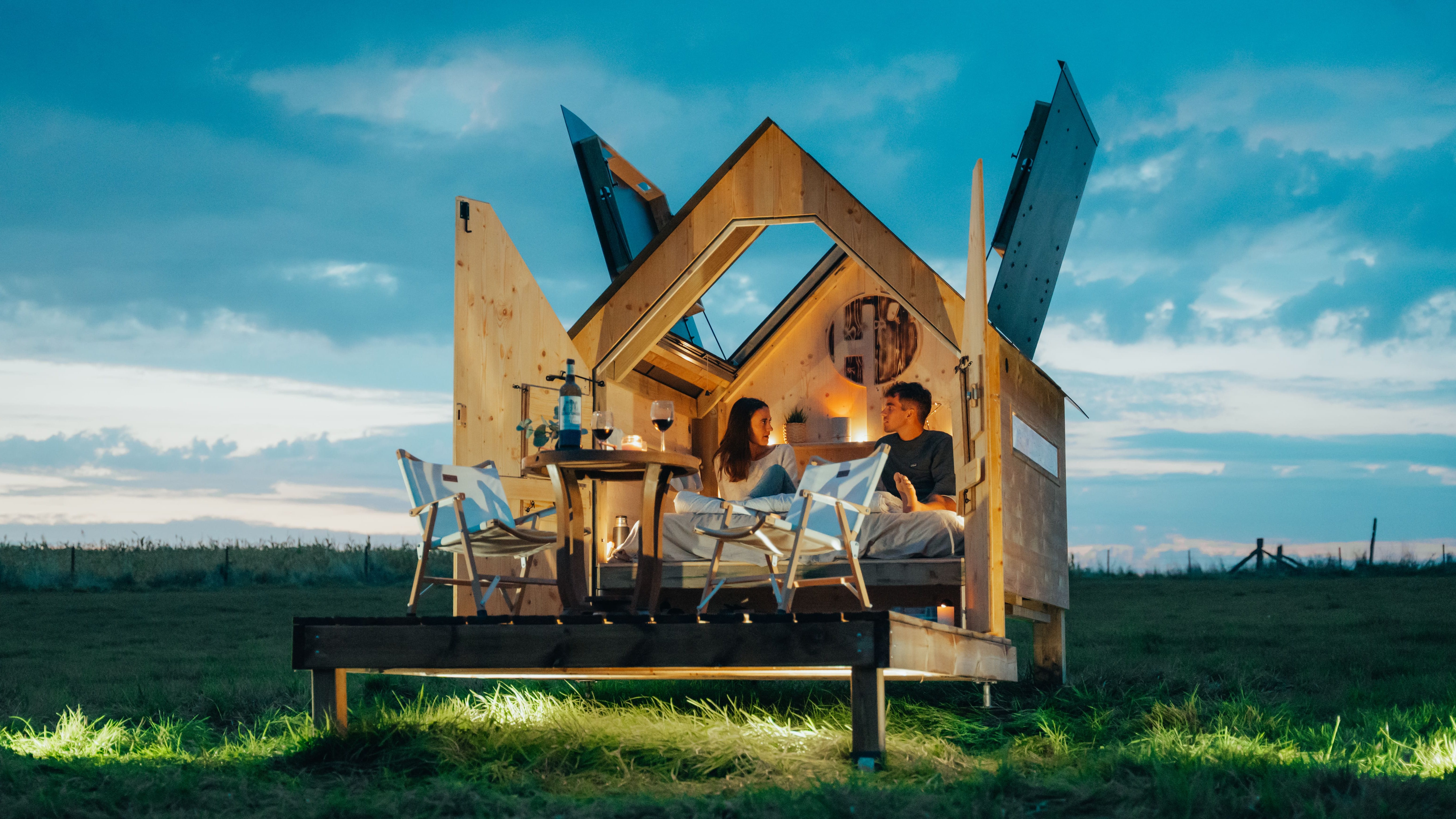 deux personnes dans une cabane hut'op éclairée de nuit dans un champ vert